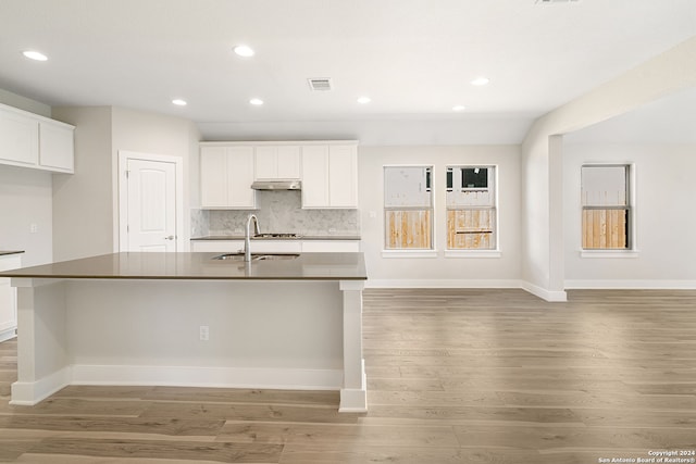 kitchen with a spacious island, white cabinets, and dark hardwood / wood-style floors