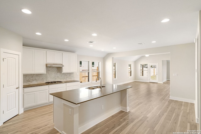 kitchen with white cabinetry, a healthy amount of sunlight, and lofted ceiling