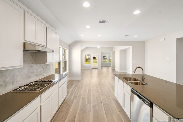 kitchen with exhaust hood, appliances with stainless steel finishes, white cabinetry, light hardwood / wood-style flooring, and sink