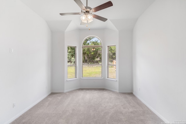 carpeted spare room featuring lofted ceiling and ceiling fan