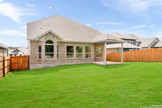 back of house featuring a lawn and a patio area