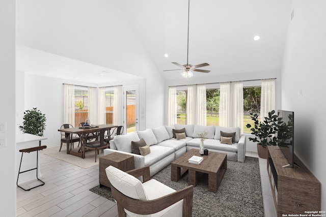 living room featuring ceiling fan, light hardwood / wood-style flooring, and high vaulted ceiling