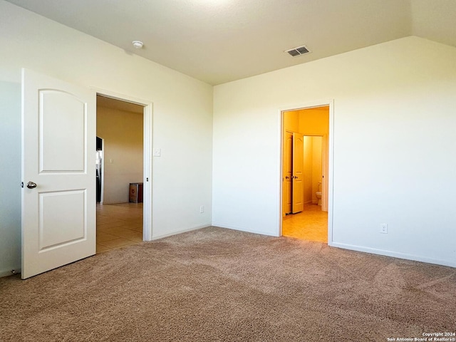 spare room with vaulted ceiling and light carpet