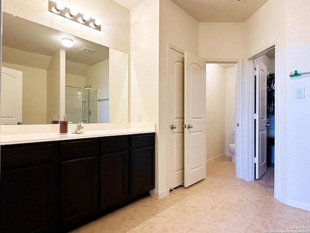 bathroom with walk in shower, vanity, and toilet