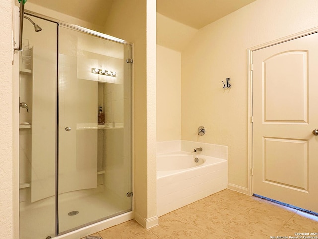 bathroom with shower with separate bathtub, tile patterned floors, and vaulted ceiling