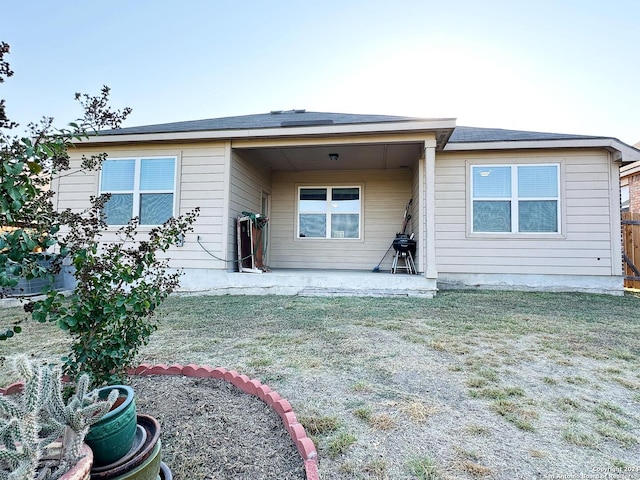 rear view of property featuring a yard