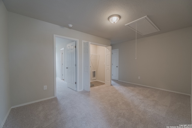 empty room featuring light carpet and a textured ceiling