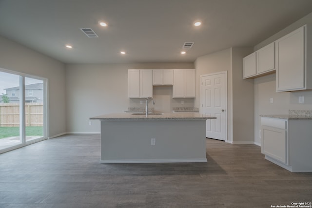 kitchen with a center island with sink, white cabinetry, and wood-type flooring