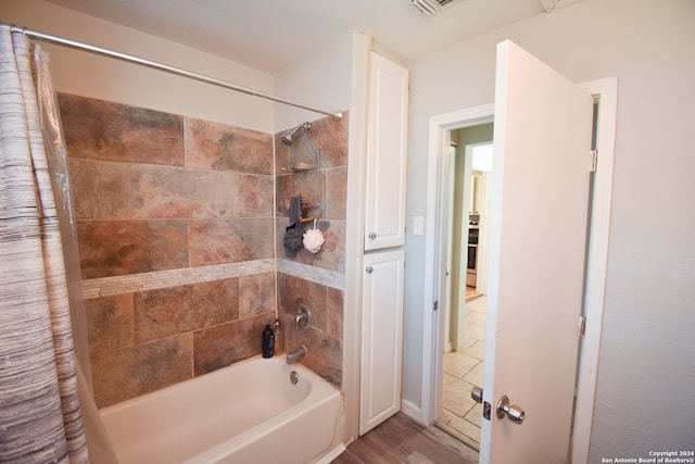 bathroom with hardwood / wood-style flooring and shower / tub combo with curtain