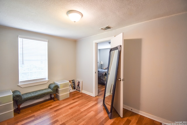 sitting room featuring a textured ceiling and light wood-type flooring