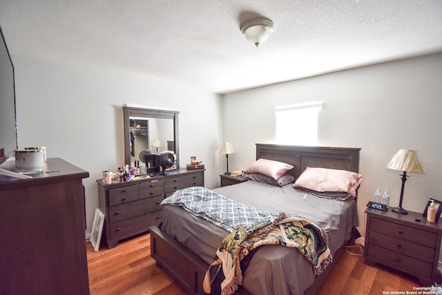 bedroom with wood-type flooring and a textured ceiling