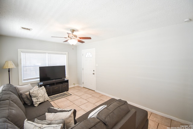 tiled living room with ceiling fan and a textured ceiling