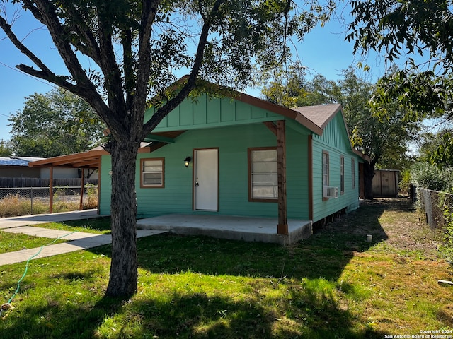 bungalow-style house featuring a front yard and cooling unit