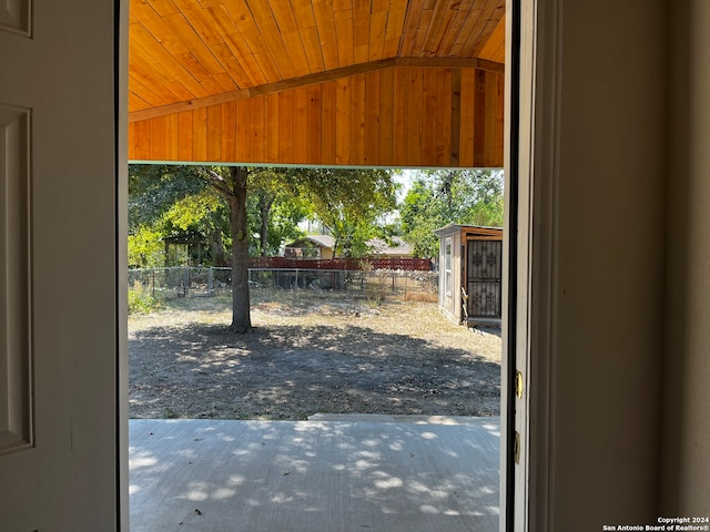 doorway with lofted ceiling and wooden ceiling