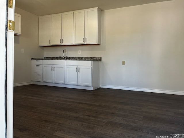 bar with sink, dark hardwood / wood-style flooring, and white cabinetry