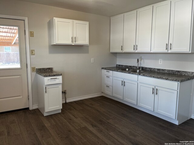 kitchen featuring dark hardwood / wood-style floors, white cabinets, and sink