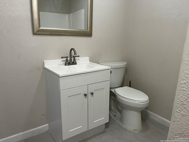 bathroom with vanity, toilet, and tile patterned floors