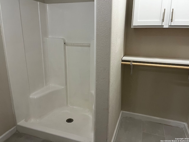 bathroom with tile patterned flooring and walk in shower