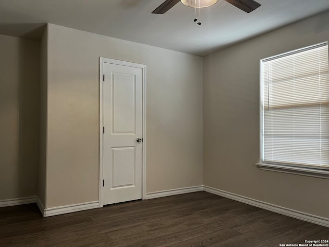 unfurnished room featuring ceiling fan and dark wood-type flooring