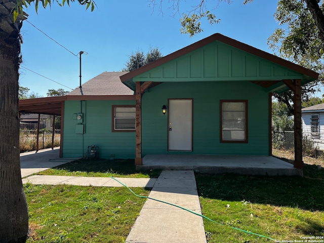 bungalow-style home with a carport and a front yard