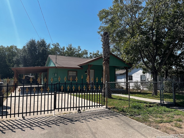 view of gate featuring a lawn and a carport