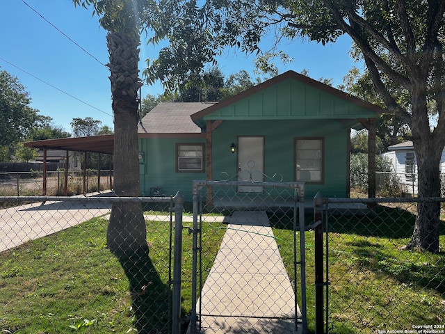 bungalow featuring a front lawn and a carport