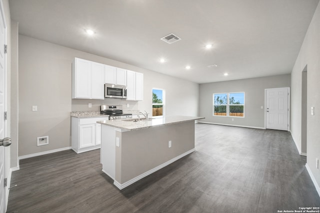 kitchen with dark hardwood / wood-style flooring, sink, stainless steel appliances, an island with sink, and white cabinetry