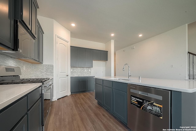 kitchen featuring decorative backsplash, a center island with sink, dark wood-type flooring, sink, and stainless steel appliances