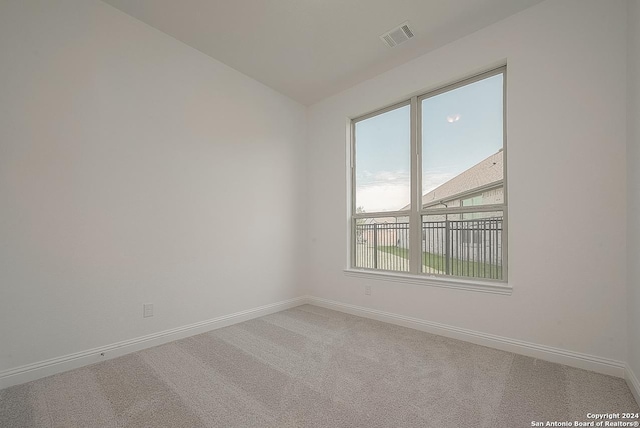 spare room featuring carpet flooring and lofted ceiling