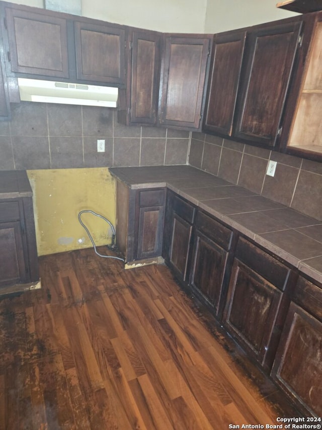 kitchen with tile countertops, dark hardwood / wood-style flooring, and decorative backsplash