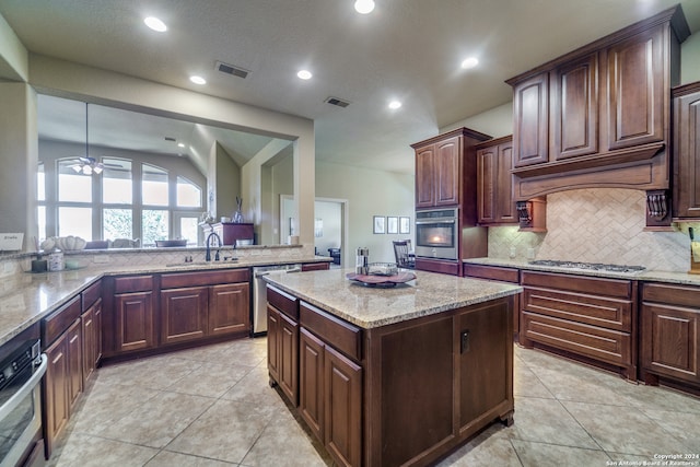 kitchen with dark brown cabinetry, appliances with stainless steel finishes, light tile patterned floors, and lofted ceiling