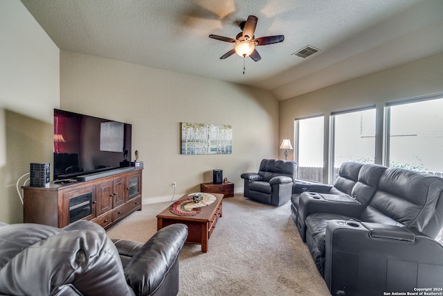 carpeted living room with ceiling fan, a textured ceiling, and vaulted ceiling