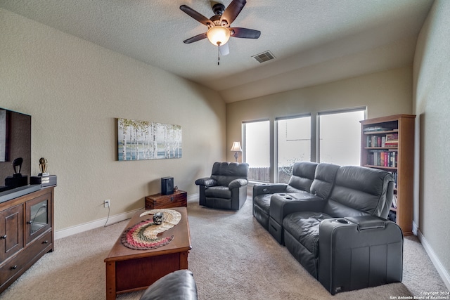 living room with light carpet, a textured ceiling, vaulted ceiling, and ceiling fan