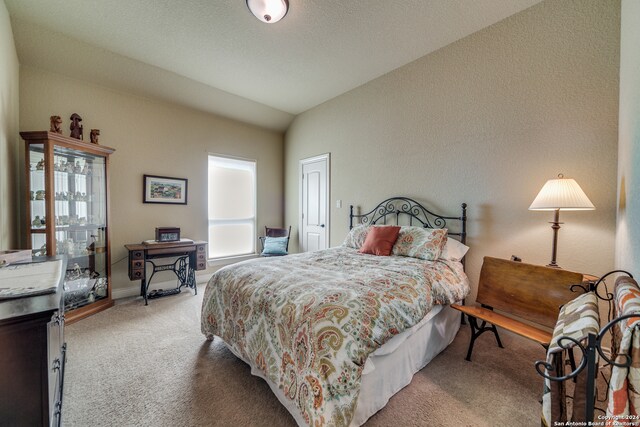 carpeted bedroom with lofted ceiling