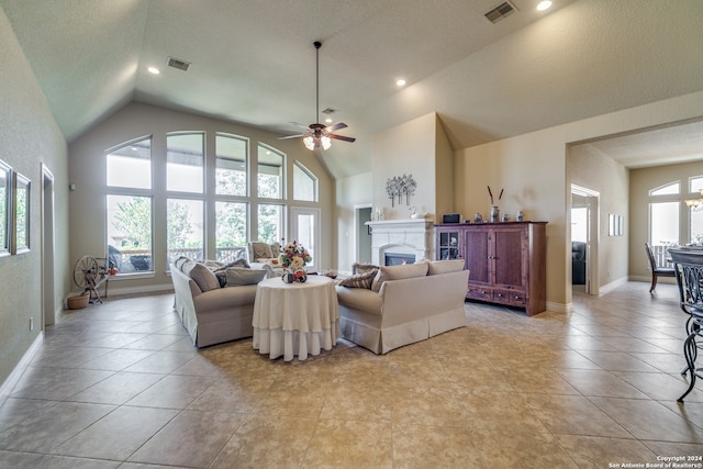 tiled living room featuring ceiling fan, a textured ceiling, high vaulted ceiling, and a healthy amount of sunlight