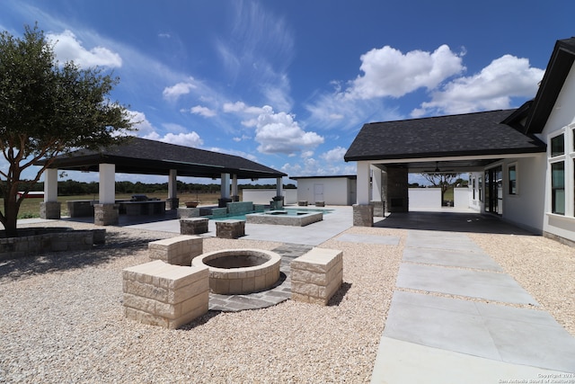 view of patio featuring a fire pit, a pool with hot tub, and a gazebo