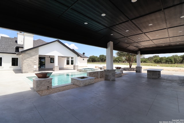 view of swimming pool featuring an in ground hot tub and a patio