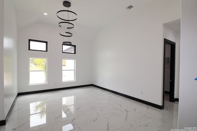 unfurnished room featuring lofted ceiling