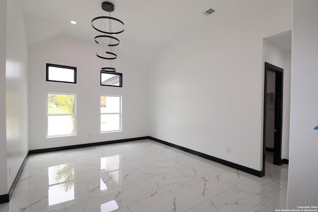 unfurnished living room with high vaulted ceiling, visible vents, marble finish floor, and baseboards