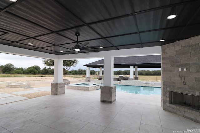 pool featuring a gazebo, an in ground hot tub, an outdoor stone fireplace, a ceiling fan, and a patio