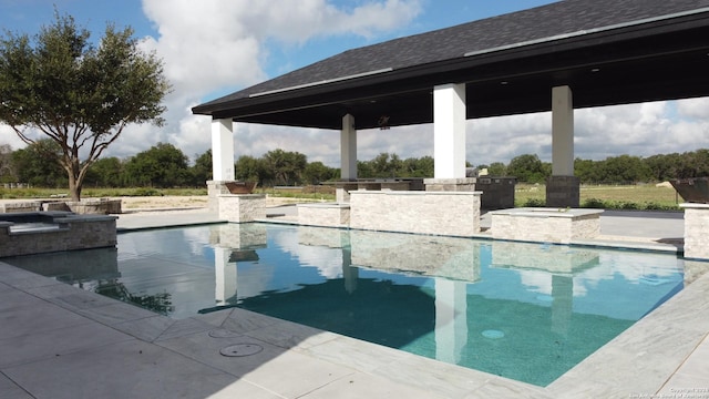 pool featuring a gazebo, an outdoor bar, a patio, and exterior kitchen