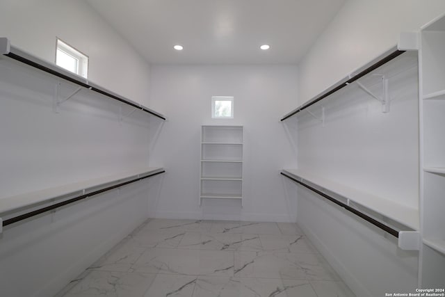 spacious closet featuring marble finish floor