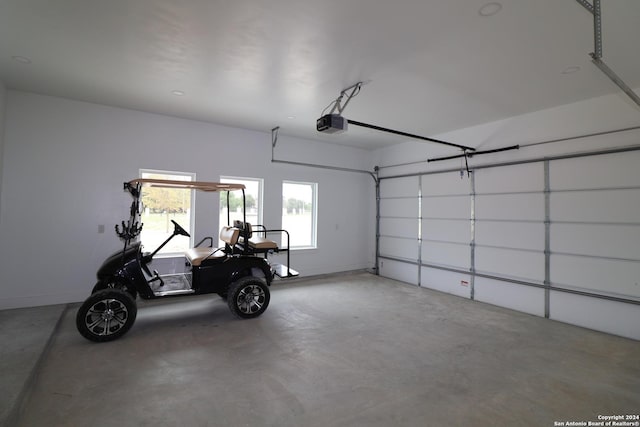 garage with baseboards and a garage door opener