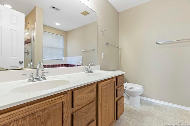 bathroom with vanity, toilet, a shower with door, and tile patterned floors