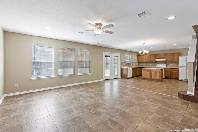 kitchen featuring ceiling fan with notable chandelier, white appliances, decorative light fixtures, and a textured ceiling