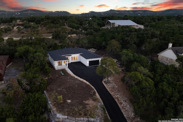 aerial view at dusk featuring a mountain view