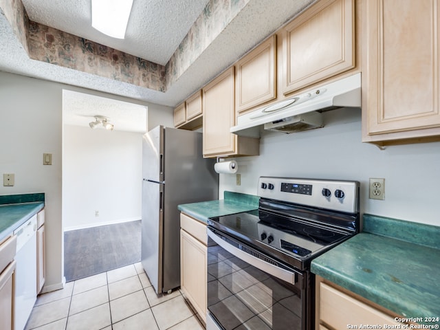 kitchen featuring light tile patterned flooring, light brown cabinets, appliances with stainless steel finishes, and a textured ceiling