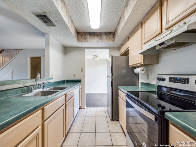 kitchen with a raised ceiling, light tile patterned floors, sink, a textured ceiling, and appliances with stainless steel finishes