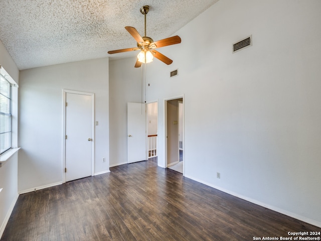 unfurnished bedroom featuring dark wood-type flooring, high vaulted ceiling, a textured ceiling, and ceiling fan