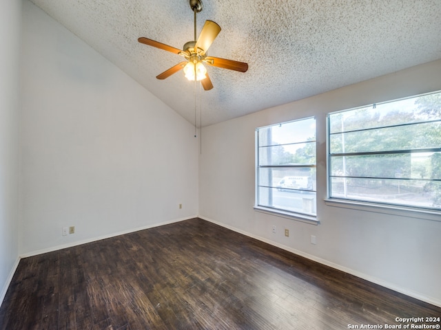 empty room featuring lofted ceiling, ceiling fan, dark hardwood / wood-style floors, and a textured ceiling